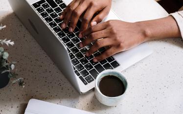 Una persona escribe en el teclado de una computadora